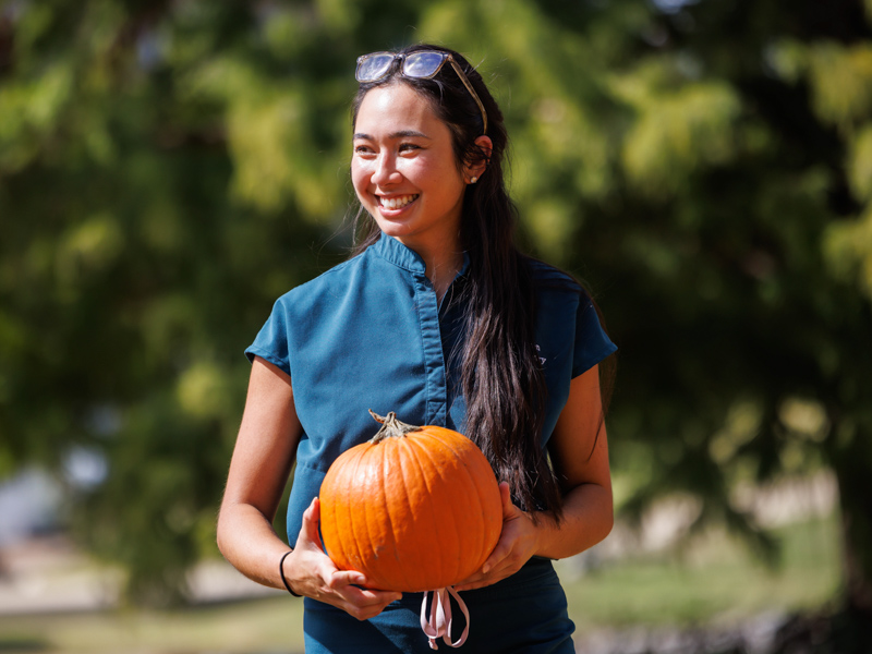 School of Dentistry students Tianna Nguyen is all smiles picking out a pumpkin from the ASB patch on campus.